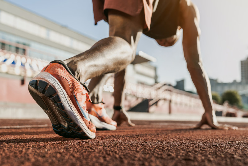 Nahaufnahme eines männlichen Athleten, der sich auf die Laufstrecke vorbereitet